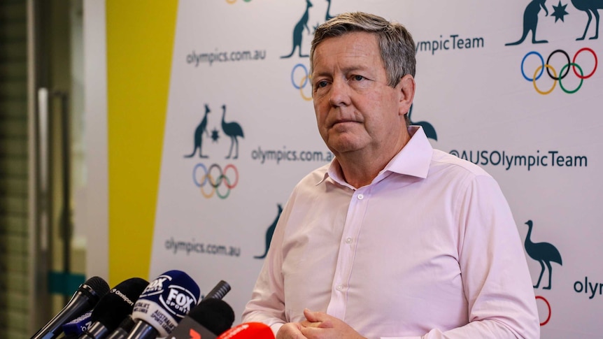 A middle-aged man stands at a podium.