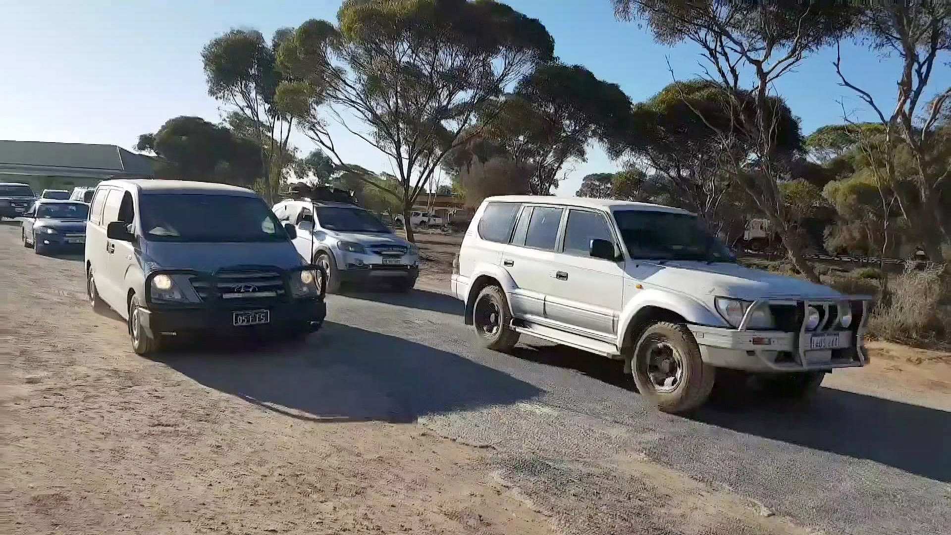 Cars drive on a stretch of bitumen.