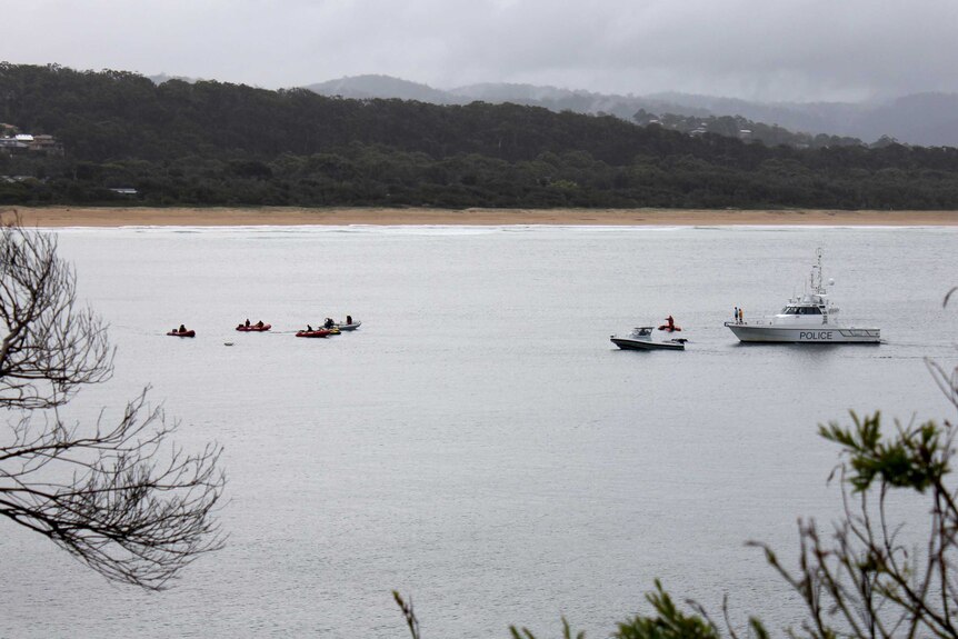 Several boats search the area where Ms Armstrong was taken at Tathra.