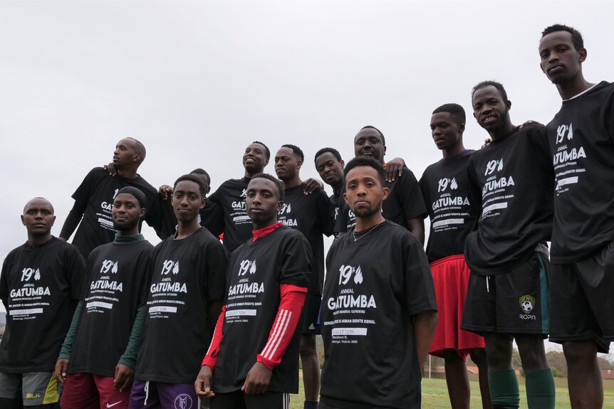 A soccer team lines up wearing memorial tee shirts. 