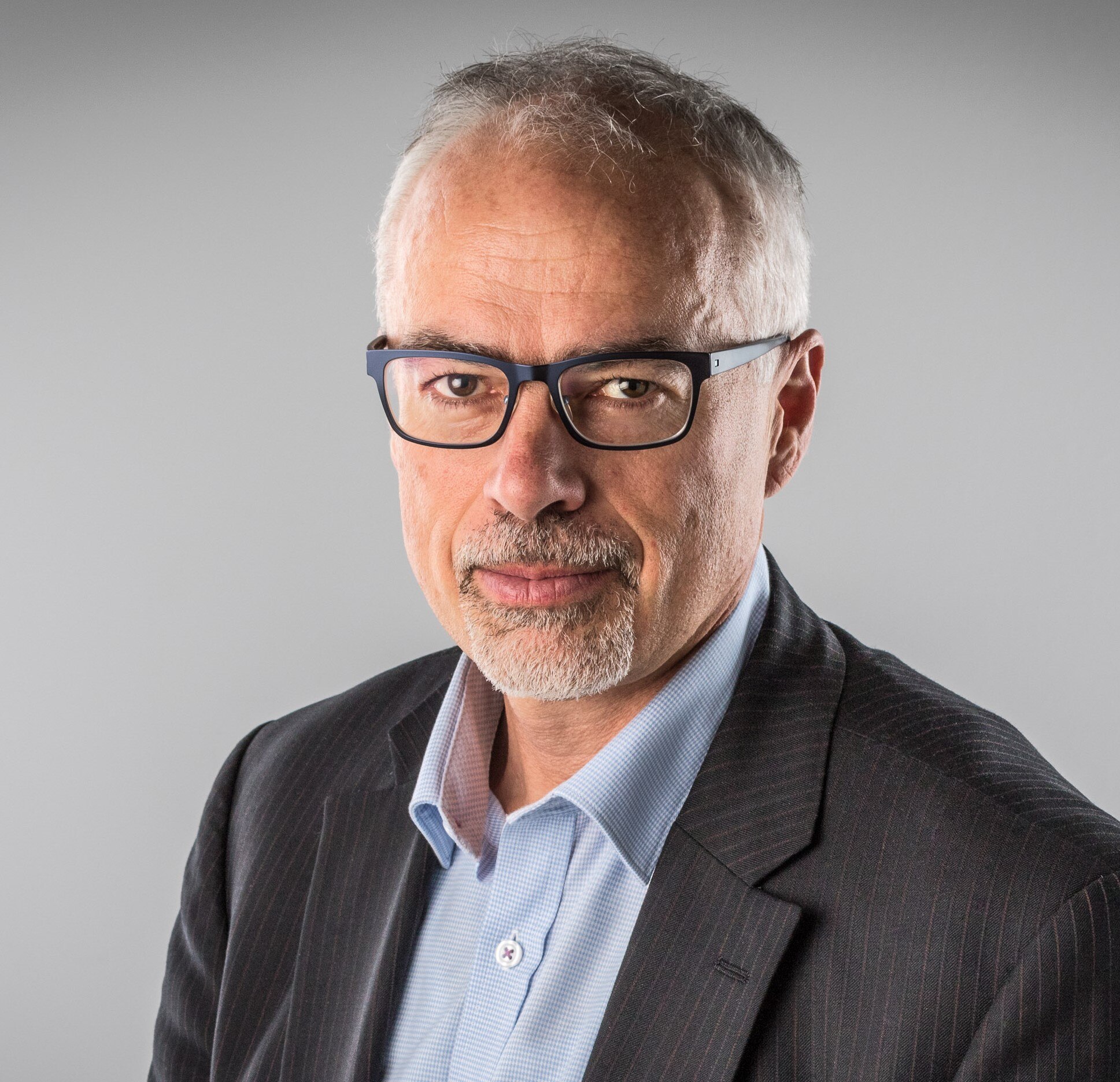 A headshot of Tony Blakely a man wearing glasses