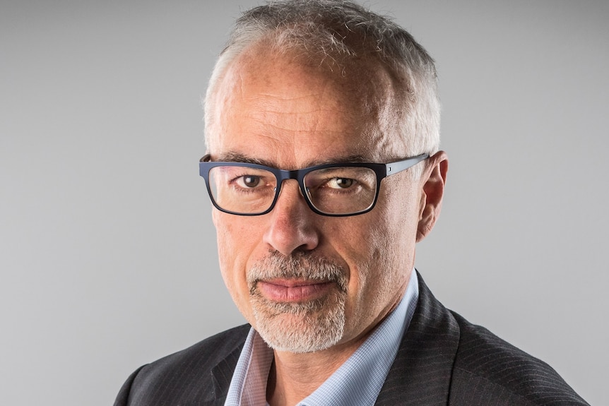 A headshot of Tony Blakely a man wearing glasses