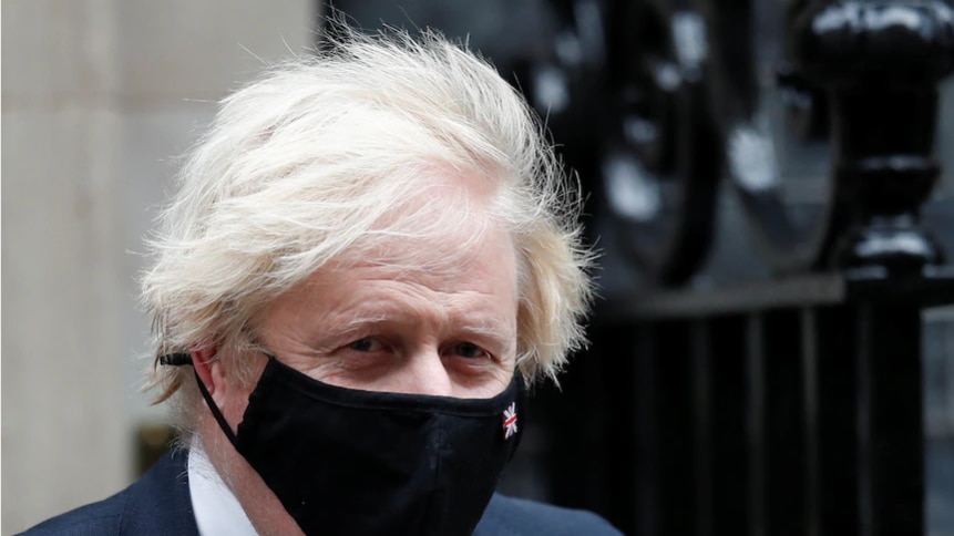 Boris Johnson wears a black mask.