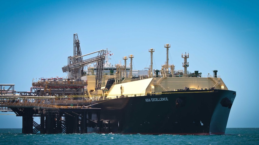 Large ship with words Asia Excellence on the side near a platform in the ocean.