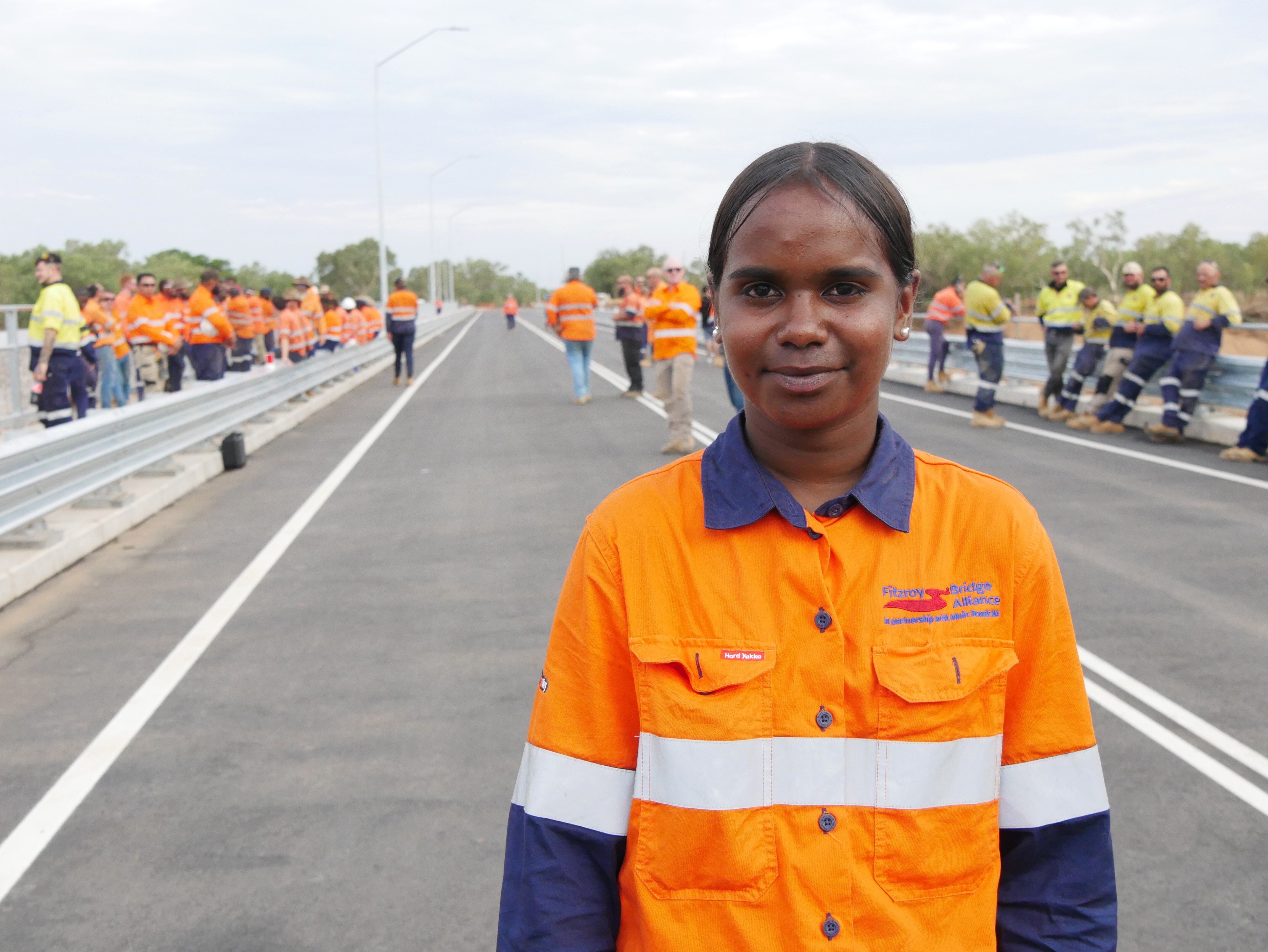A woman standing on a bridge wearing a Hi Vis shirt.