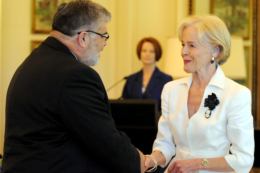 Prime Minister Julia Gillard watches as Governor General Quentin Bryce swears in Senator Kim Carr.