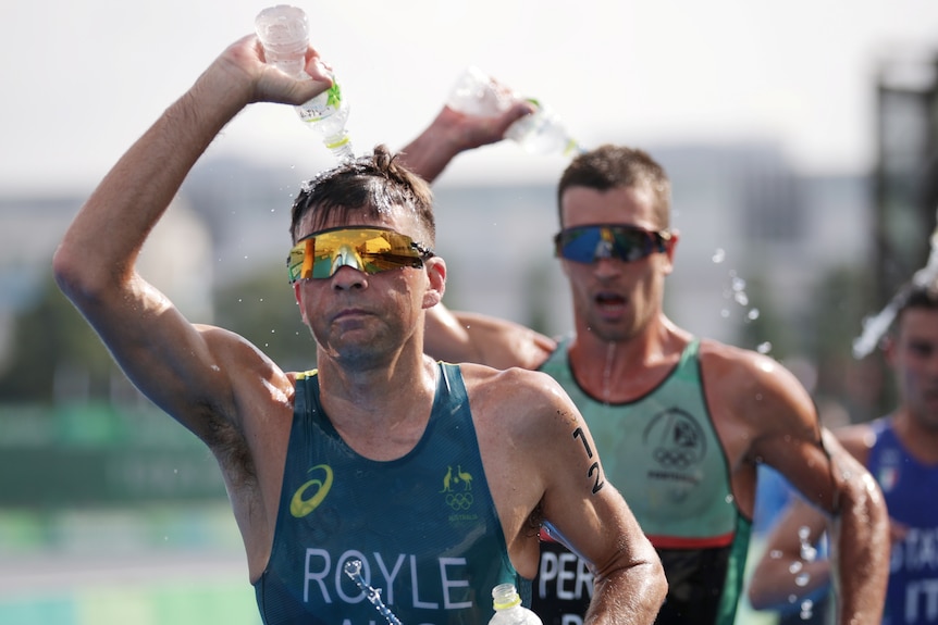 Aaron Royale pours water on his head during the triathlon. 