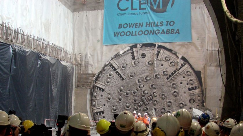 Workers gather at the site where the giant boring machine broke through