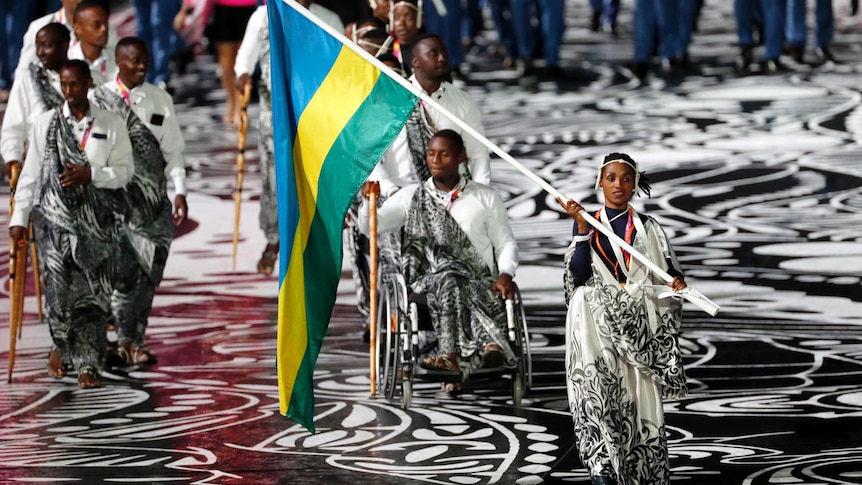 Salome Nyirarukundo of Rwanda carries the national flag during the Commonwealth Games opening ceremony.