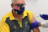 Scott Morrison, wearing an Australia flag face mask, is giving a vaccine jab in his arm by a nurse.