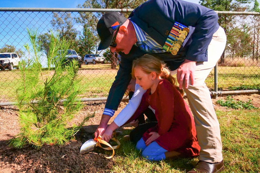 A war veteran and a little girl help plant a lone pine