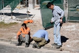 Workers from a nearby worksite gather following a man's death on a building site in Carlingford, northwest of Sydney.