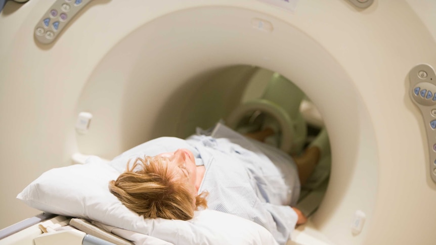 Person getting a CAT scan in an x-ray machine