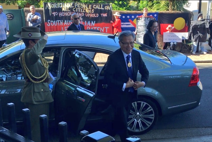 Governor Hieu Van Le gets out of a car in front of protestors.