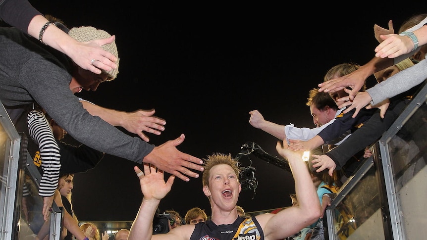 Winners are grinners: Jack Riewoldt celebrates with fans after kicking four goals in Richmond's win.