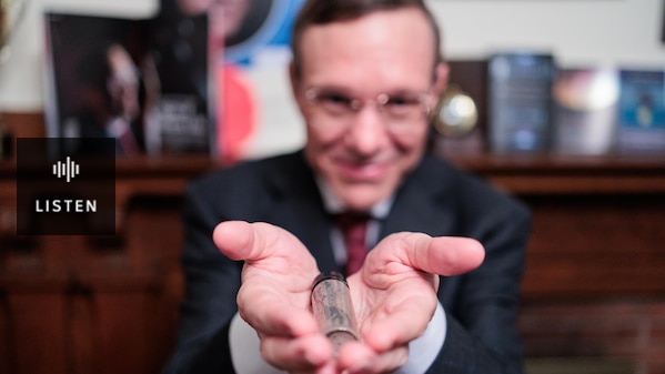Physicist Avi Loeb holds out a tube containing meteor fragments collected from the bottom of the Pacific Ocean. Has Audio.