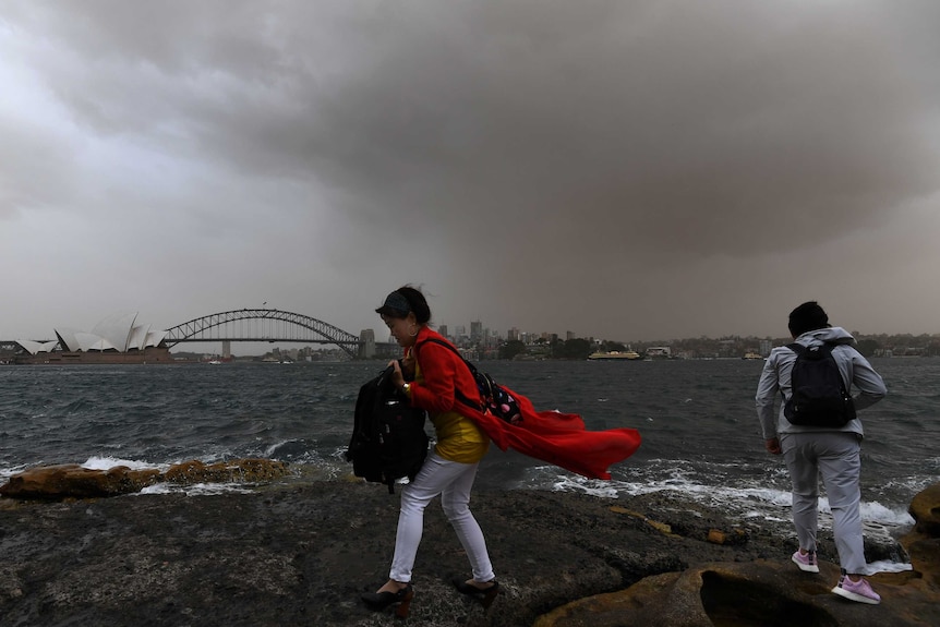 People stand on Sydney Harbour during a dust storm