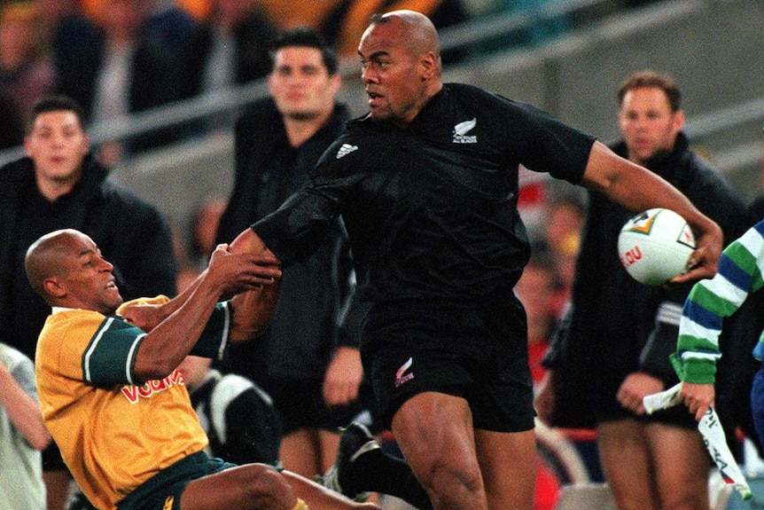 George Gregan hangs off Jonah Lomu in 2000