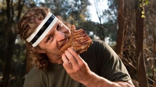 man with headband eating a big steak 
