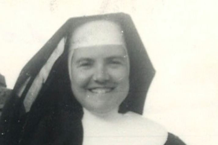 A black and white photo of a  young nun