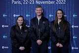 Three ESA astronauts stand and smile.