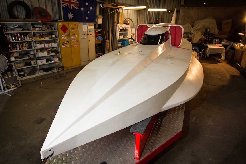 A speed boat sits on a trailer.