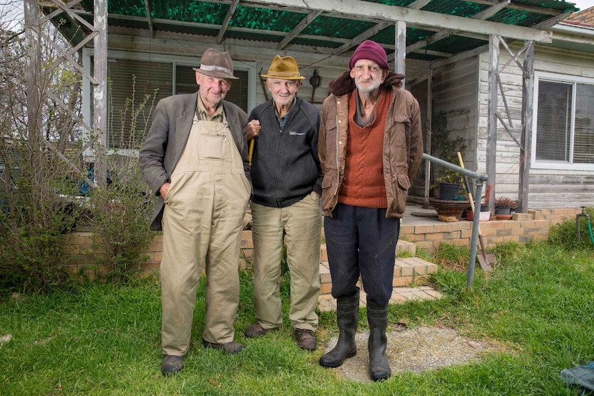 Brothers Edward, Garry and Keith Troutbeck stand at the front of their home