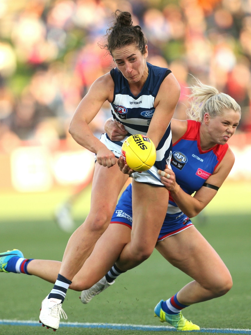 Rebecca Goring of the Cats is tackled by Katie Brennan of the Bulldogs.