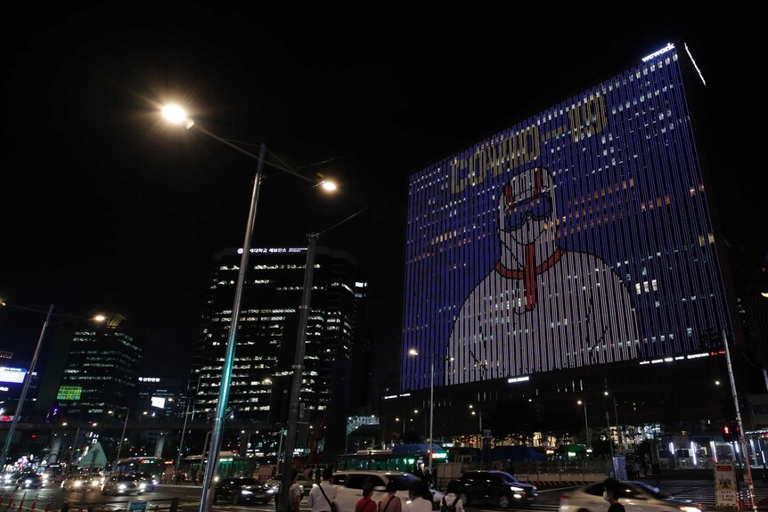 A message of gratitude and support for health workers appears on a building in Seoul.