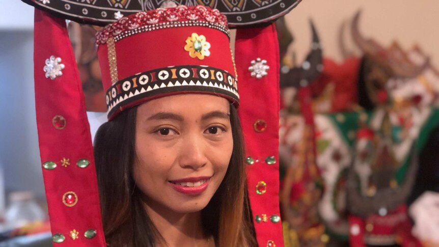 Kristianingsih Dian Rahayu wearing a red head ornament with tassels.