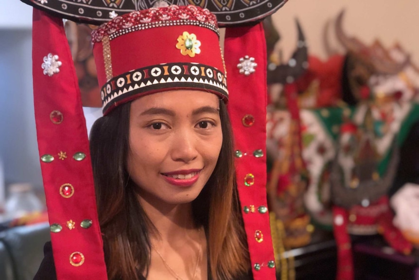 Kristianingsih Dian Rahayu wearing a red head ornament with tassels.