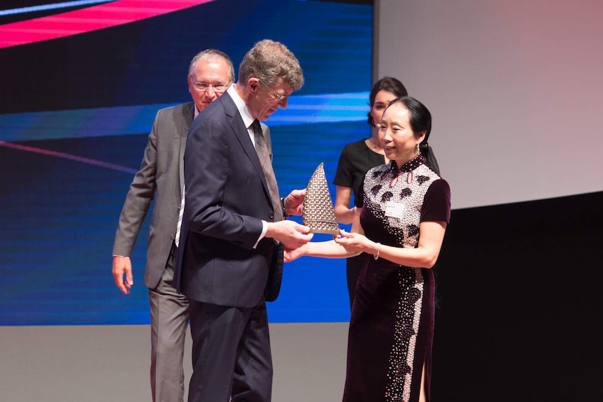 A man and woman accepting a prize on a stage