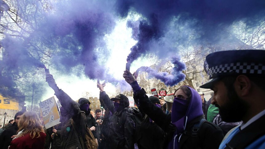 Protesters let off purple smoke.