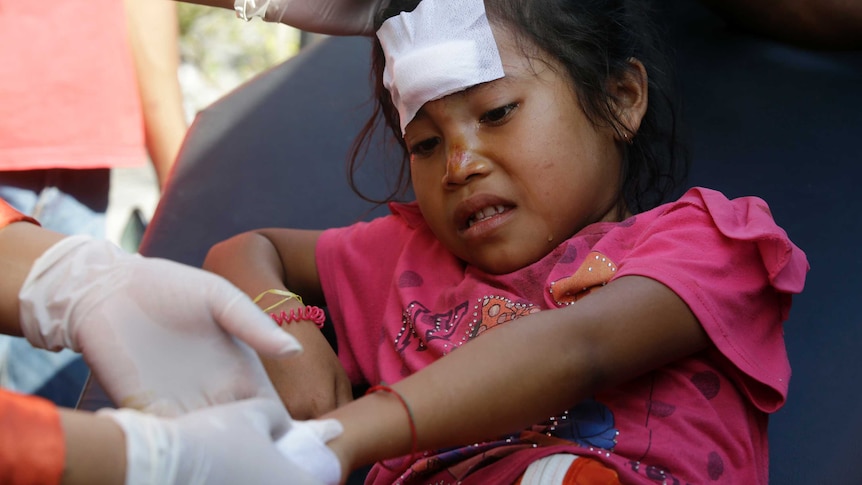 A girl injured in an earthquake is treated in Mataram, Lombok, Indonesia