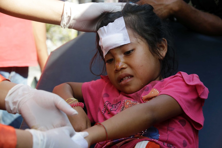 A girl injured in an earthquake is treated in Mataram, Lombok, Indonesia