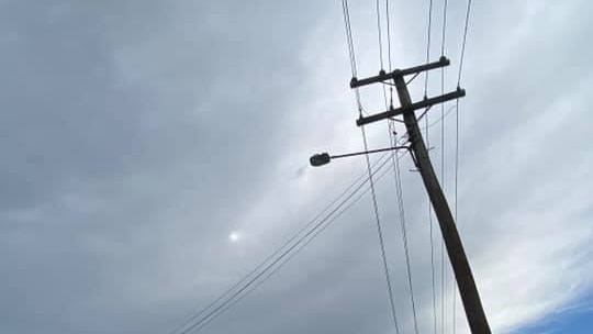 A street lined with leaning power poles.