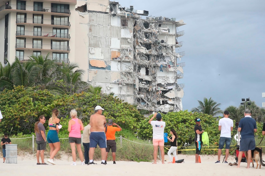 People look at the damage at the 12-story oceanfront Champlain Towers South Condo that collapsed early Thursday, June 24, 2021.
