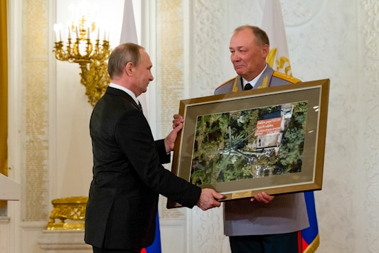Vladimir Putin hands a framed photograph to  Aleksandr Dvornikov, who looks very touched