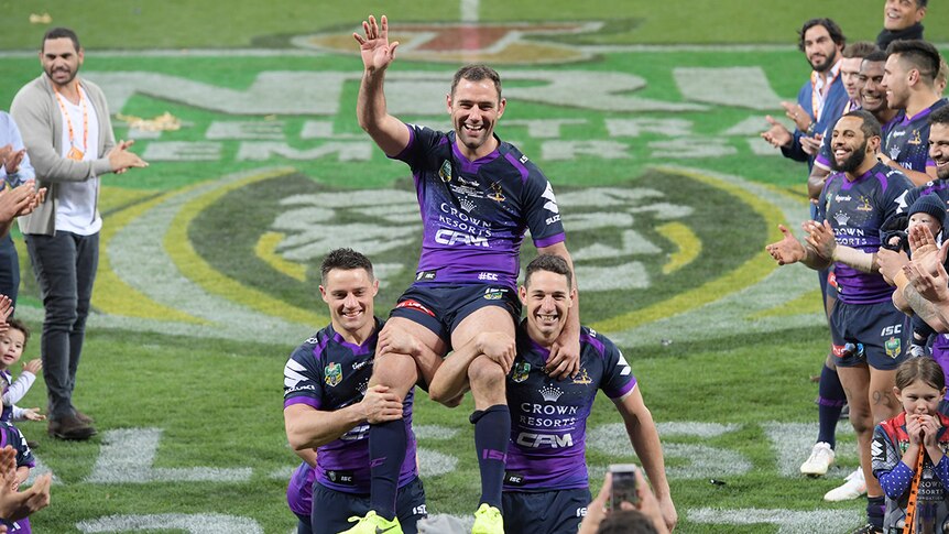 The Storm's Cameron Smith waves as he is chaired off by Billy Slater and Cooper Cronk.
