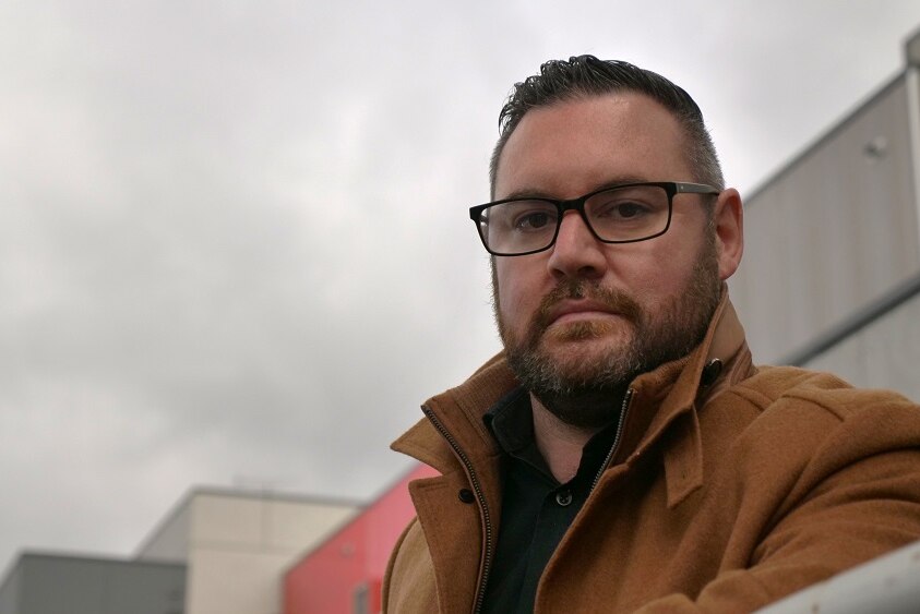 A man with a heavy jacket looks at the camera.