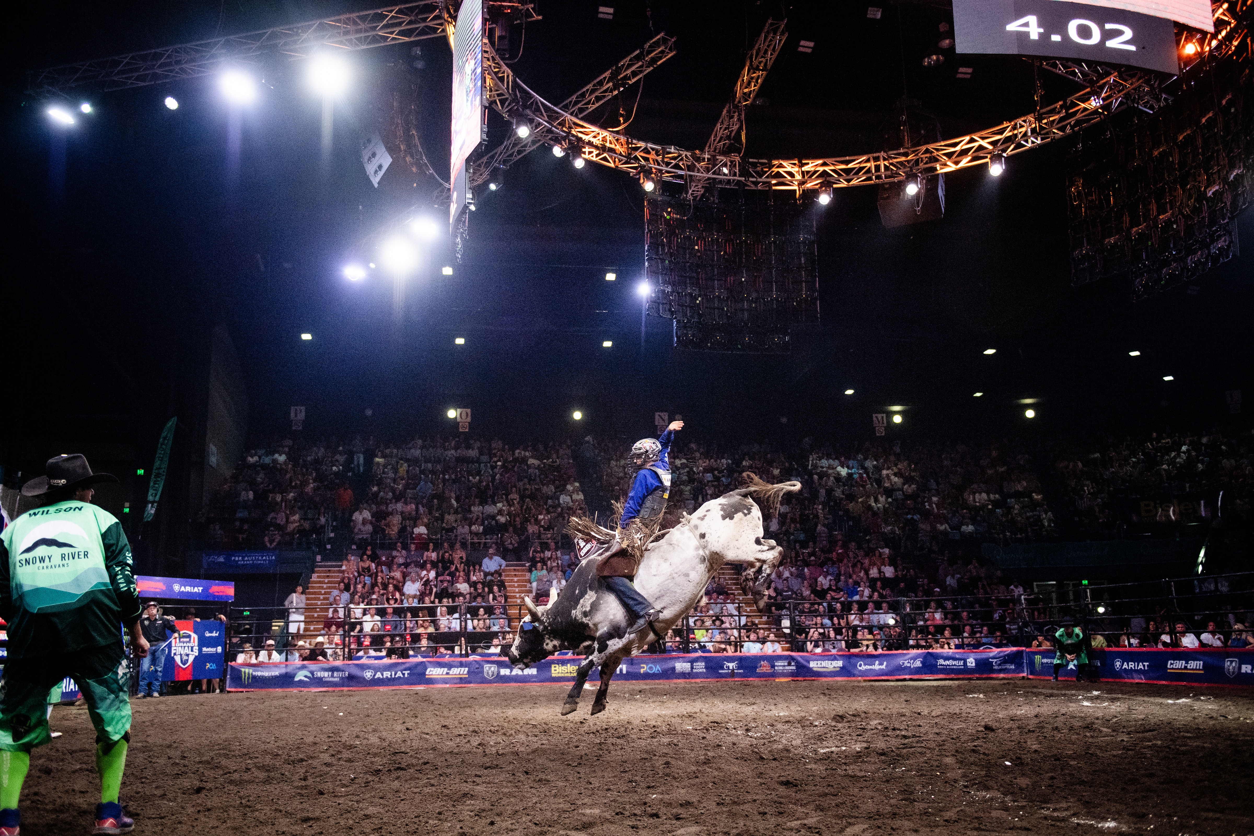 A rider on a bucking bull at a rodeo.