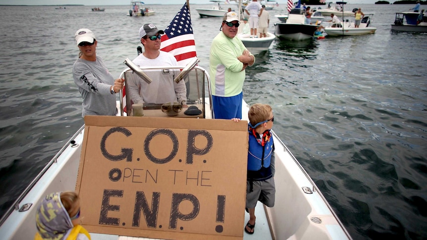 A fishing guide and his family participate in a floating protest.