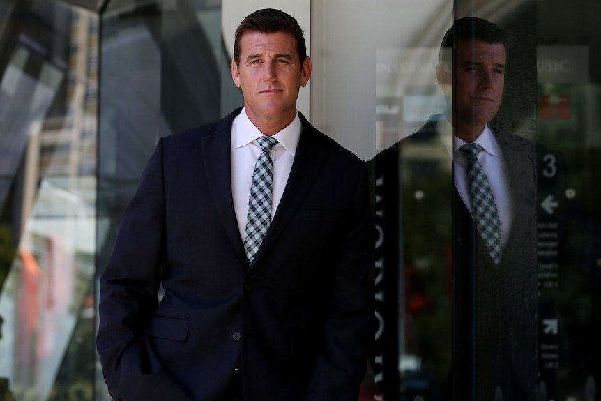 man leaning on a glass wall