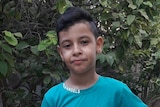 Kareem, a small boy who died in Gaza,  pictured in a backyard.