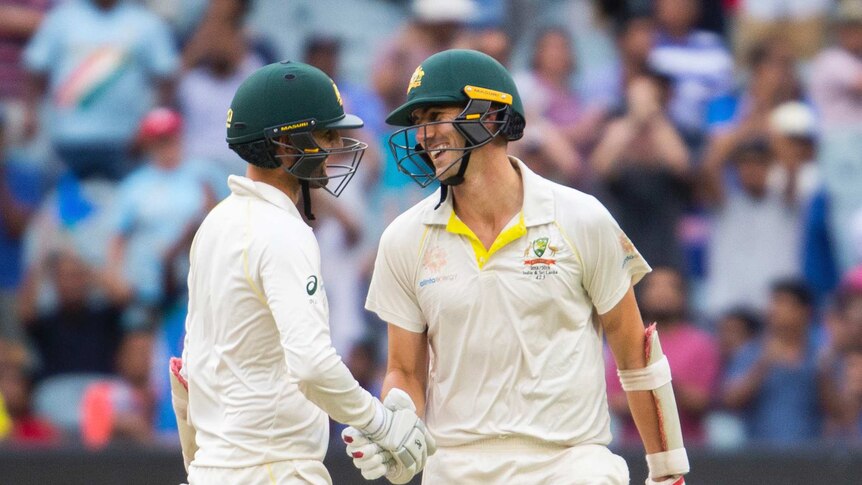 Pat Cummins and Nathan Lyon share a laugh after surviving to stumps at the MCG