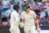 Pat Cummins and Nathan Lyon share a laugh after surviving to stumps at the MCG