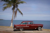 A vintage car is parked on the Rincon coast in Puerto Rico