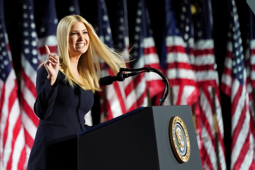 Ivanka Trump speaks at a podium in front of a row of American flags.
