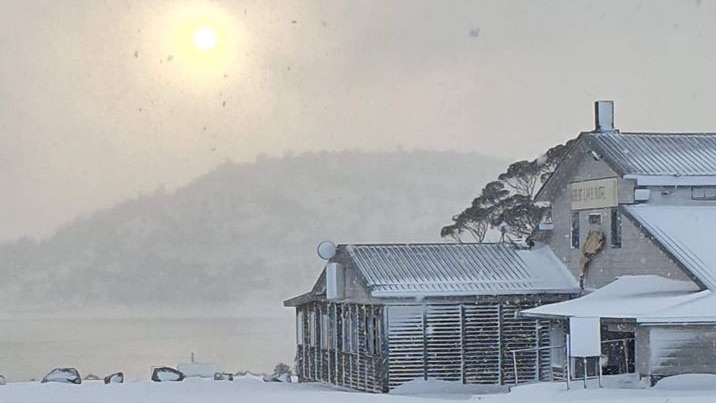 The sun glows in a snowy sky at the Great Lakes Hotel.