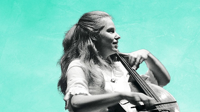 A black-and-white photograph of a young Jacqueline du Pre playing the cello, on a cyan background.